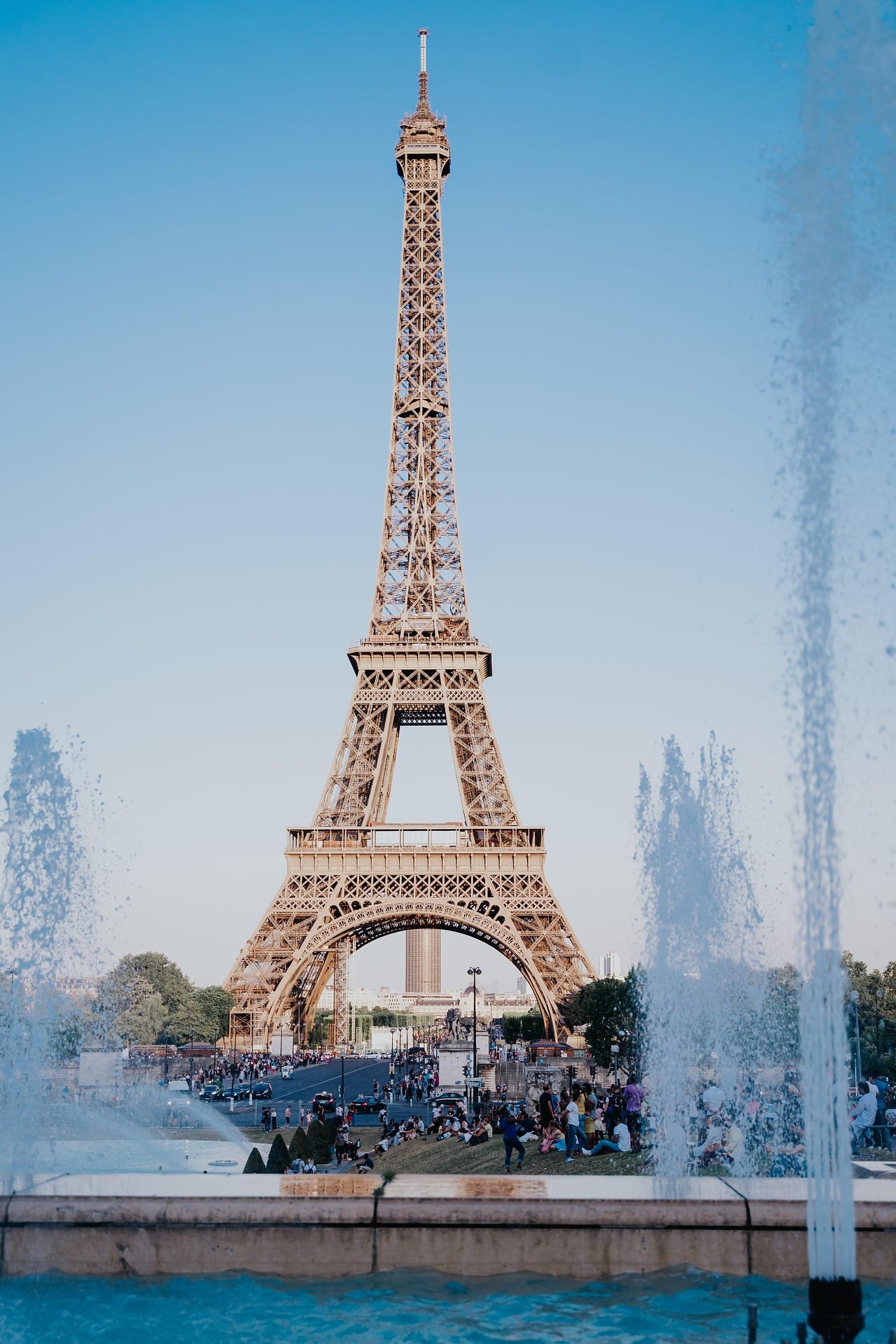 The Eiffel Tower seen through the spray of fountains on a clear day.